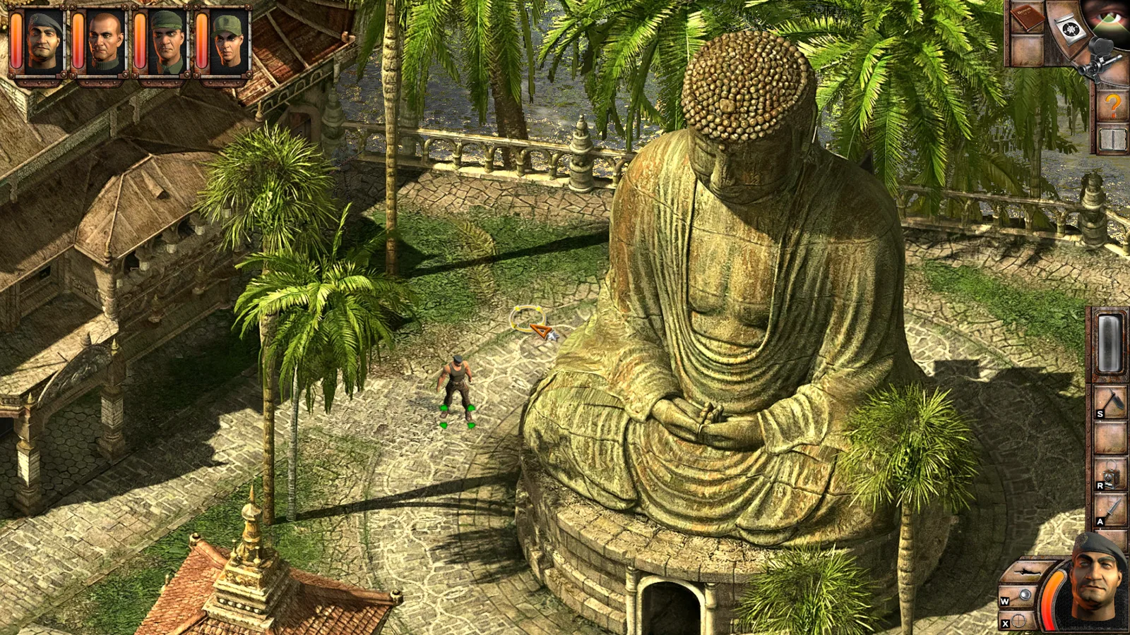 A commando beside a giant stone Buddha statue among palm trees in Commandos 2: HD Remaster