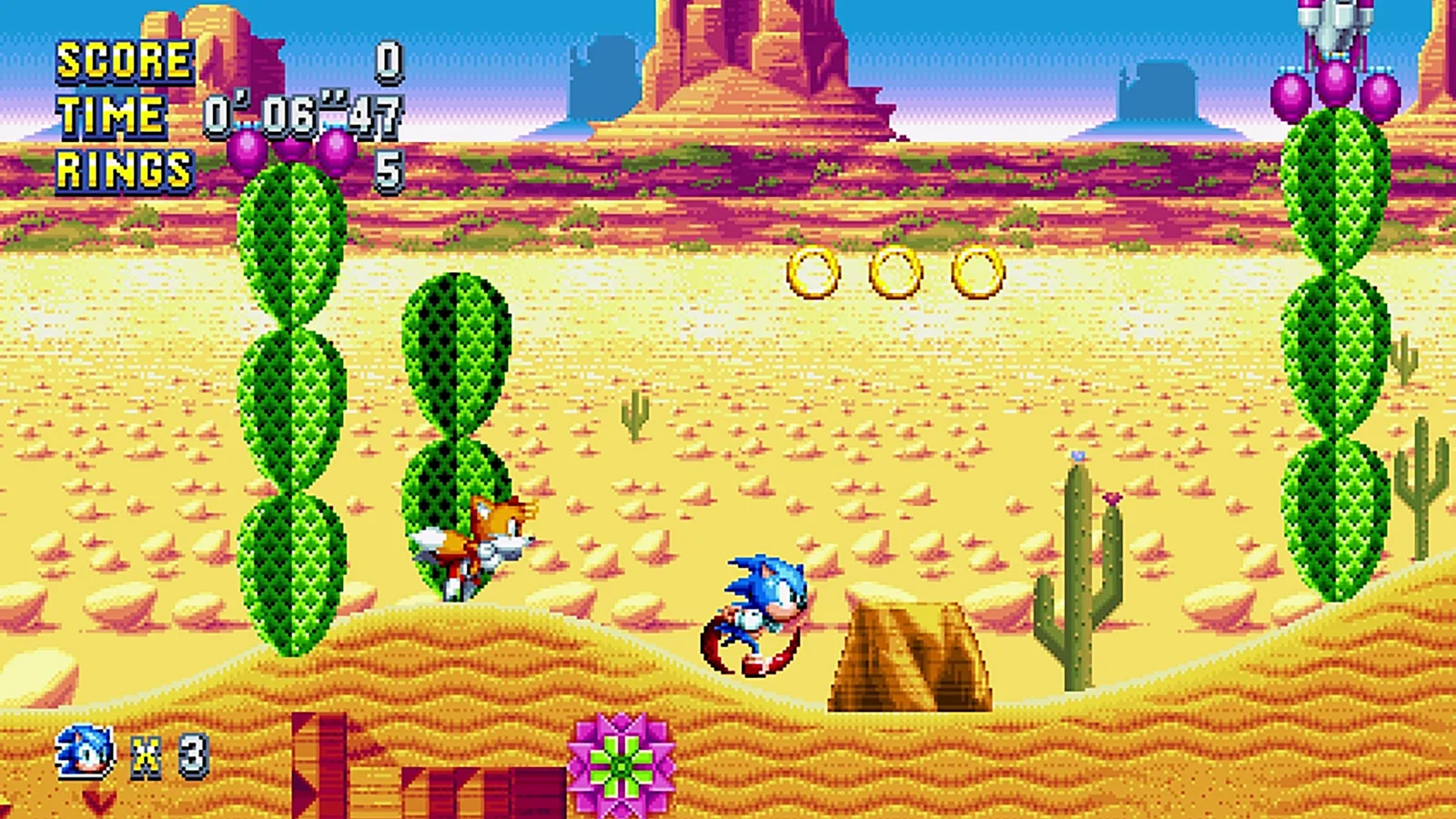 Sonic and Tails in a pixel-art desert zone with tall cacti, rock mesas and a row of rings